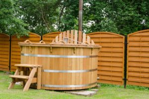 A wooden hot tub in a backyard